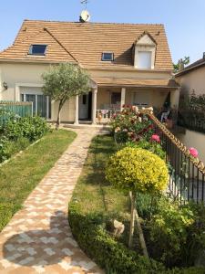 a house with a walkway in front of a yard at Appartement cosy à Sannois de 110 m² avec jardin clôturé in Sannois