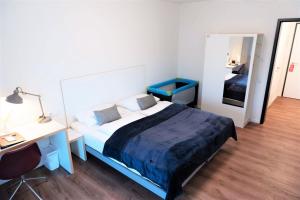 1 dormitorio con cama, escritorio y espejo en Gästehaus Hansa Residence en Hamburgo