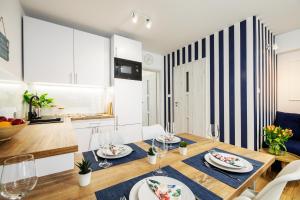 a kitchen and dining room with a table and chairs at Apartament 11B Blue Marine Poddąbie in Poddąbie