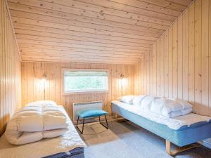 a bedroom with a large bed in a wooden room at Secluded Cozy Cottage in Skaven-By Traum in Tarm +29 photos