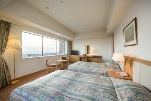 سرير أو أسرّة في غرفة في Grand Hotel New Oji