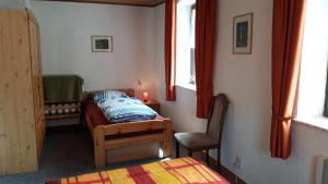 ein kleines Zimmer mit einem Bett und einem Stuhl darin in der Unterkunft Gasthaus Zehrermühle in Schönberg