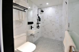 a white bathroom with a toilet and a sink at Home Rest Hotel 2 in Taitung City