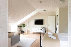 a room with a bed and a couch and a tv at Hotel Nestor & Restaurant Back Pocket in Korppoo