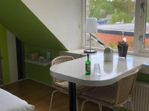una mesa y sillas blancas en una habitación con ventana en B&B De Gouden Vlo en Donkerbroek