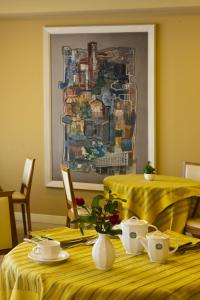 a table with a yellow table cloth and a painting at Sangallo Palace in Perugia