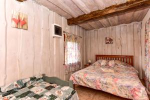 1 dormitorio con 2 camas en una habitación con paredes de madera en Prie Melnyčios, en Dubingiai