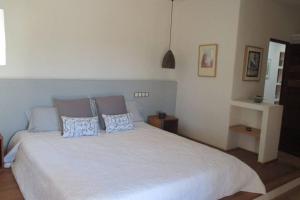 a bedroom with a large white bed with two pillows at Sa Vinyeta in Sant Llorenç de Balafia +21 photos