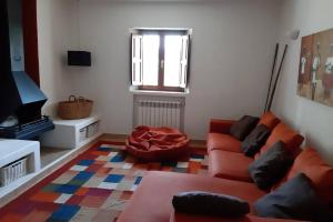 a living room with a red couch and a television at Sa Vinyeta in Sant Llorenç de Balafia