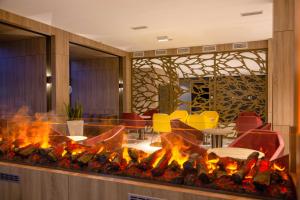 Avar Hotel في ماترافوريد: موقد في بهو فندق مع كراسي