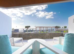 a balcony with chairs and a view of the ocean at Hotel Lava Beach in Puerto del Carmen