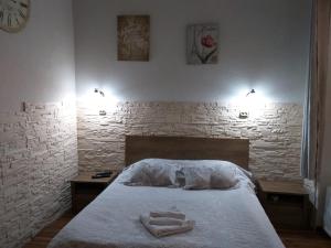 1 dormitorio con 1 cama con 2 toallas en Raphaela Residence, en Bistriţa