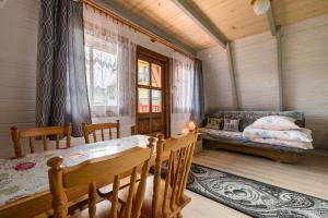 a dining room with a table and a couch at DOMKI u JÓZKA in Polańczyk