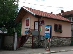 un pequeño edificio con un cartel delante en Стаи за гости ОРЕХА Троян Private rooms Oreha en Troyan