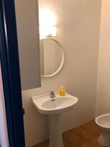 y baño con lavabo blanco y espejo. en Apartamentos Mediterranean View en Llançà