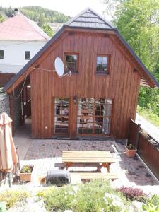 ein Holzgebäude mit einem Picknicktisch davor in der Unterkunft Chata Ema in Špania Dolina