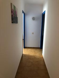 un corridoio vuoto con due porte e pavimento piastrellato di Apartamentos Mediterranean View a Llança