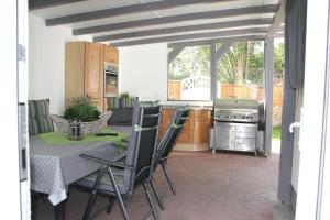 eine Küche mit einem Tisch und Stühlen auf einer Terrasse in der Unterkunft Ferienhaus Glücksmoment in Blankenburg