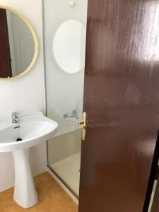 baño con lavabo y puerta con espejo en Apartamentos Mediterranean View en Llançà