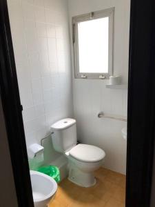 baño con aseo blanco y ventana en Apartamentos Mediterranean View en Llançà