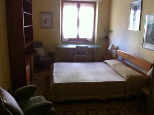 ein kleines Schlafzimmer mit einem Bett und einem Fenster in der Unterkunft Appartamento Signorile in Alghero