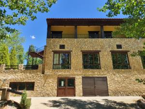 ein Steinhaus mit Balkon darüber in der Unterkunft HOTEL MASIA EL MOLINETE in Mora de Rubielos