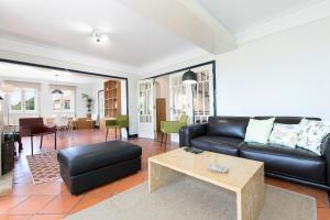 uma sala de estar com um sofá preto e uma mesa em LV Premier Granja Villa- GR1 em Granja