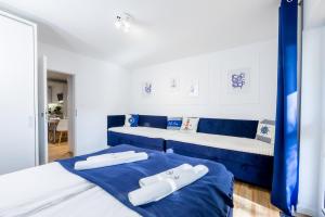 two beds in a room with blue and white at APARTAMENT 9B BLUE MARINE Poddąbie Basen Odkryty Brodziki Plac Zabaw in Poddąbie +30 photos