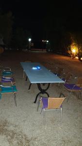 a picnic table and chairs in a field at night at Oasis Studios AG PANTES in Áyioi Pándes