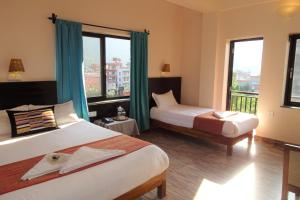 Habitación de hotel con 2 camas y ventana en Hotel Karuna, en Pokhara