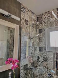 a bathroom with a shower with a glass door at Pearl City View Apartment in Paphos City