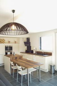 une cuisine avec une table en bois et deux chaises blanches dans l'établissement Le Saint-Jore - 2 bedroom apartment balcony & parking, à Saint-Jorioz