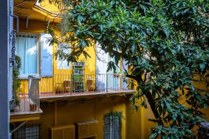 a yellow building with a balcony with chairs and a tree at Mars41 B&B in Bologna