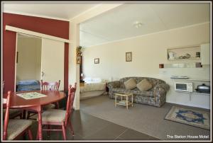 uma sala de estar com uma mesa e um sofá em The Station House Motel em Collingwood