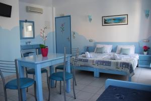 a bedroom with a bed and a table and chairs at Mastorakis Village in Agia Marina Nea Kydonias