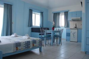 a bedroom with a bed and a table and a kitchen at Mastorakis Village in Agia Marina Nea Kydonias