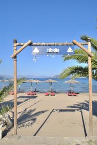 a beach with chairs and umbrellas and the ocean at Marathona's Apartment in Aegina Town