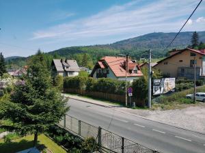 a view of a street with houses and a fence at Apartamenty Pod Gondolą in Szczyrk