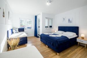 dwa łóżka w pokoju z niebieskim i białym w obiekcie APARTAMENT 19B BLUE MARINE Poddąbie Basen Odkryty Brodziki Plac Zabaw w Poddąbiu +37 zdjęć