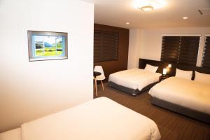 En eller flere senge i et værelse på Hotel Kojan