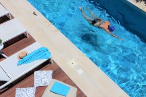 a woman swimming in a swimming pool in a swimming pool at Fos Villa, a Luxe House with Private Heated Pool in Galatás