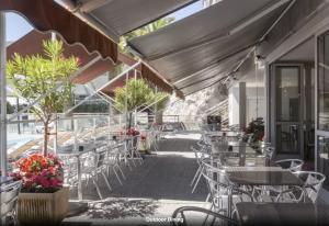 un patio al aire libre con mesas, sillas y flores en Viangella - Dramatic sea view! Top floor 2km to Monaco en Cap d'Ail