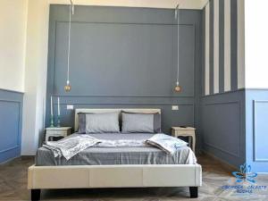 een slaapkamer met een groot bed met een blauw hoofdeinde bij B&B Orchidea Celeste in Manfredonia