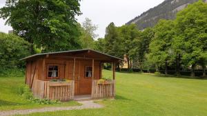 ein kleiner Holzschuppen auf einem Grasfeld in der Unterkunft Raddörfl-Campingplatz in Teufenbach