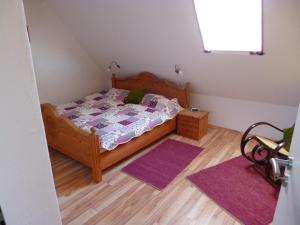 a bedroom with a bed and two purple rugs at Nordseerex in Ahrenshöft