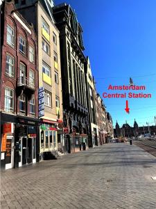 阿姆斯特丹的住宿－Dam Hotel，一条空的城市街道,有建筑和红箭