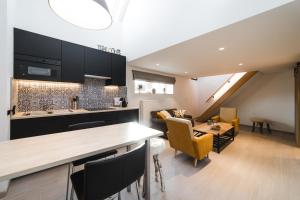 a kitchen and living room with a table and chairs at Le Cabri Ô Lait in Namur