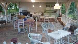 a patio with tables and chairs and a kitchen at Balzsam apartmanház in Harkány