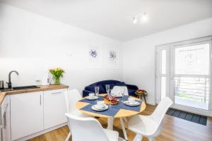 une cuisine et une salle à manger avec une table et des chaises dans l'établissement Apartament 10B Niebieskie Apartamenty z basenem krytym, odkrytym, salą zabaw, animacjami, à Poddąbie