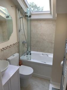 a bathroom with a tub and a toilet and a sink at Cottage in the heart of Montacute in Montacute